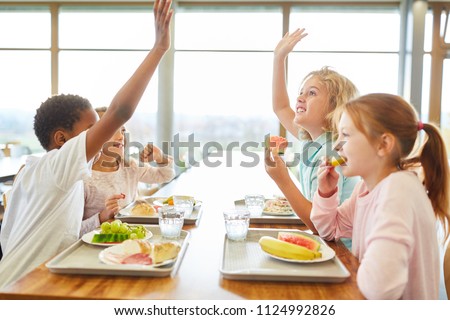 Group of children in the canteen having lunch or breakfast are having fun