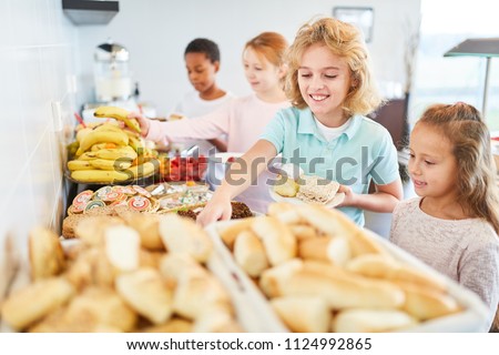 Students in elementary school pick up fruit at the buffet in the cafeteria
