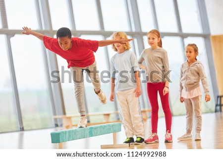 Children do school sports and balance on a balance beam