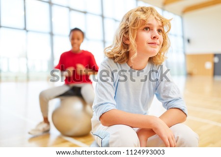Boy is resting in the gym during elementary school physical education
