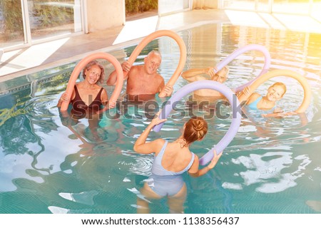 Group seniors at aquagym in the hotel pool during a wellness holiday