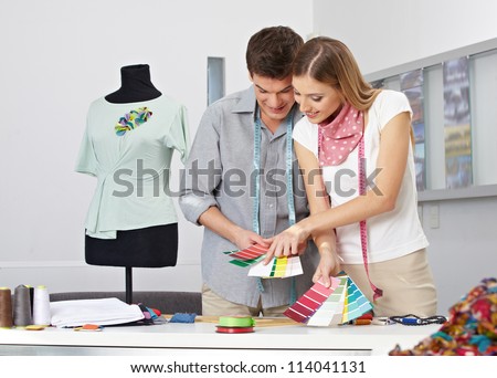 Two fashion designer making color choice with color samples in their studio