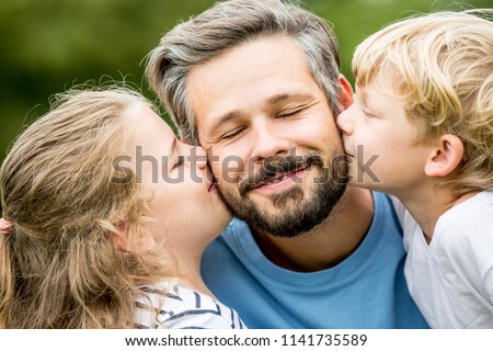 Happy children give father a kiss with love