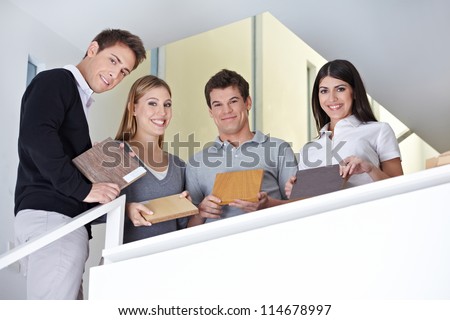 Happy sales team showing wood samples in office