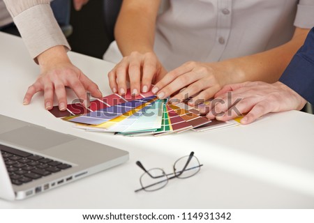 Many hands with different color pattern samples on the office table Many hands with different color pattern samples on the office table