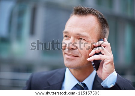 Business man in the city making a phone call with smartphone