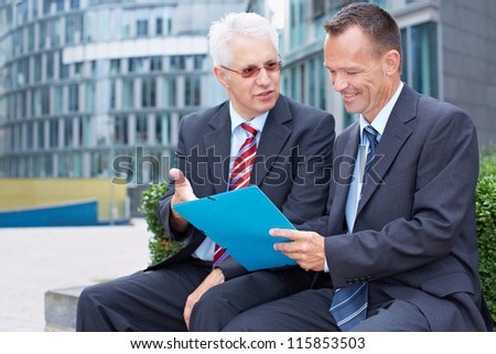 Two business men partner talking about a file