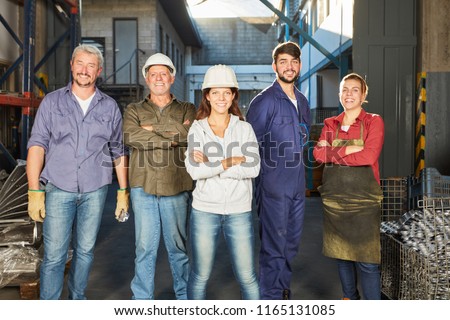 Successful self-confident team of blue collar workers in metallurgy factory