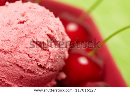 Closeup of a scoop of homemade cherry ice cream with red cherries