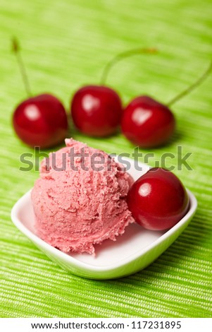 A scoop of cherry ice cream with sweet cherries