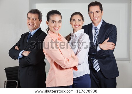 Dynamic happy busines team standing in the office with the arms crossed