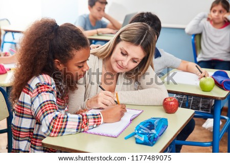 Girl gets tutoring from a teacher in elementary school or OGS