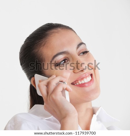 Attractive smiling business woman using her smartphone to make a call