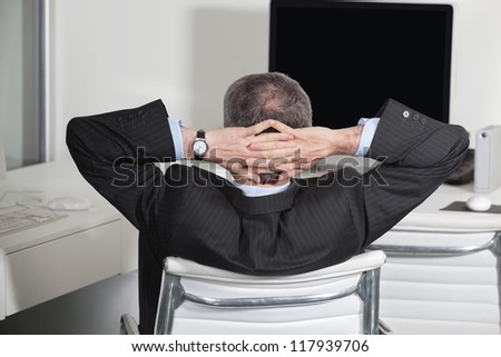 Relaxed manager at his desk leaning back in the office