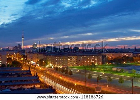 Berlin with TV tower at dusk with many lights and clouds