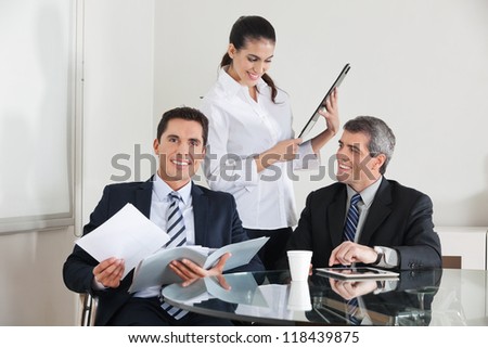 Three happy businesspeople working together in the office