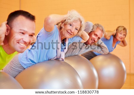 Elderly group doing back exercises in a fitness center