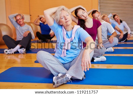 Group Doing Stretching Exercises In Back Training Class In A Fitness Center