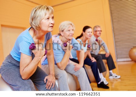 Group of senior people doing back training exercises in a gym Group of senior people doing back training exercises in a gym