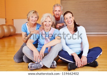 Happy group of senior citizens sitting in a fitness center gym