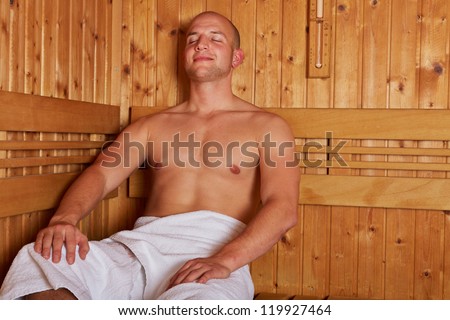 Smiling happy man sitting relaxed in a steam sauna