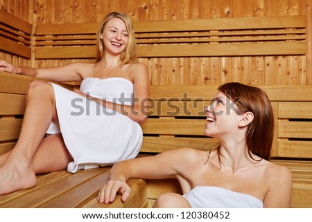 Two female friends chatting in a sauna