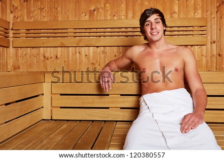 Smiling man sitting relaxed in a sauna