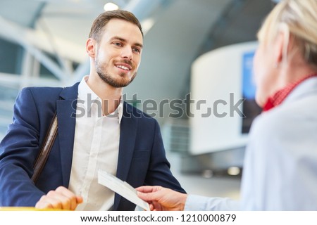 Business man as a passenger at the check-in counter during the air ticket check at the airport