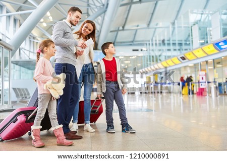 Family and children with luggage in airport terminal fly together on vacation
