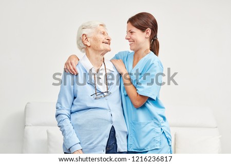 Happy elderly woman has confidence in nursing wife on a home visit