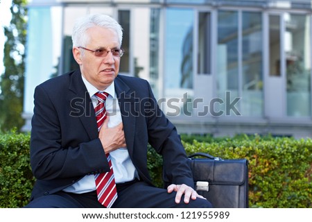 Senior business man with aching heart holding his chest