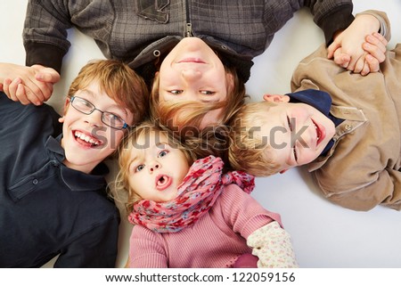 Four happy siblings in a circle looking up