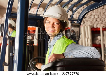Young woman in training to forklift driver in warehouse in logistics center