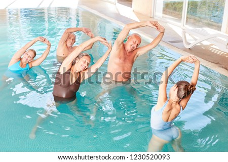Seniors in the pool doing water aerobics in a workshop in rehab