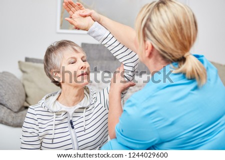 Physiotherapist makes occupational therapy exercise with senior citizen
