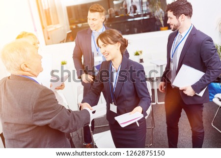 Business people shake hands after workshop as thank you sign