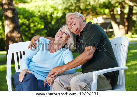 Happy senior couple sitting in a summer garden