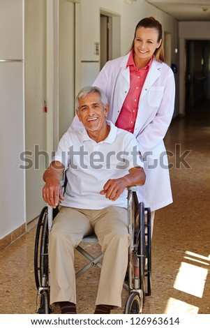 Geriatric nurse with senior man in wheelchair in a nursing home