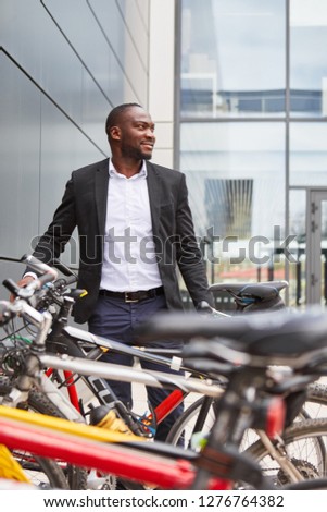 Environmentally aware businessman with bicycle as a commuter in front of his office