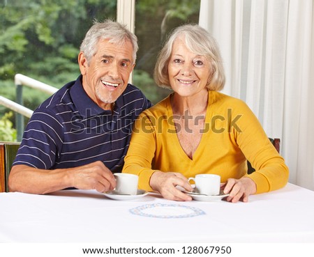 Happy senior couple drinking coffee in a retirement home
