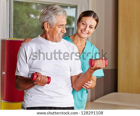 Senior man with dumbbells in rehab with a physiotherapist
