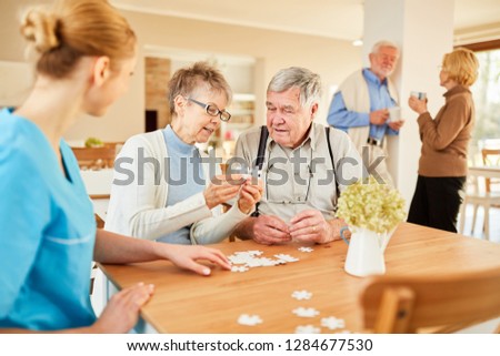 Seniors playing puzzle in their spare time in retirement home or assisted living