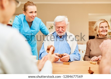 Nursing home care for seniors group with dementia in the puzzle game with wooden puzzle