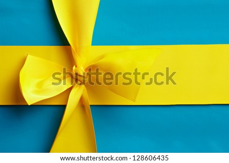 Blue gift with a yellow ribbon in the design of the national colors of Sweden