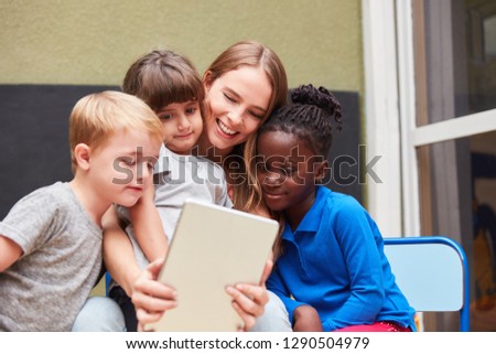 Children and teacher using a tablet PC use an app for learning and playing