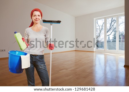 Senior woman with cleaning supplies making spring cleaning in apartment room