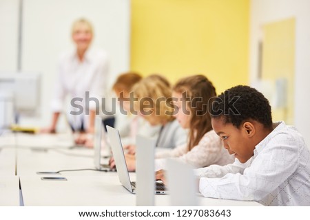 Group of students in computer Elementary school class is learning online at laptop