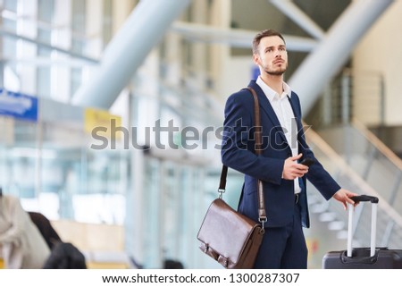 Businessman with smartphone in the airport. Terminal looks after his connecting flight