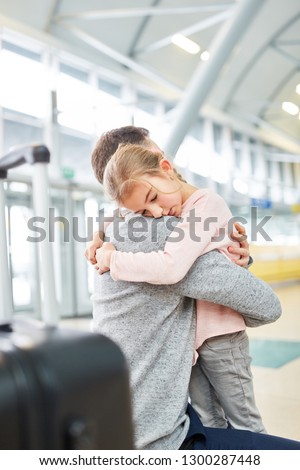 Little girl hugs her dad at the airport terminal to say goodbye before the trip