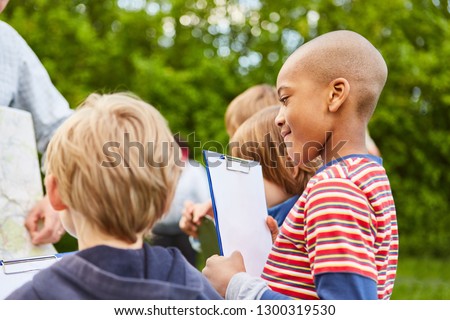 Children together make a field game or a treasure hunt in kindergarten